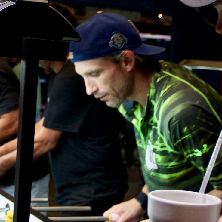 People playing foosball at a bar with drinks and snacks.